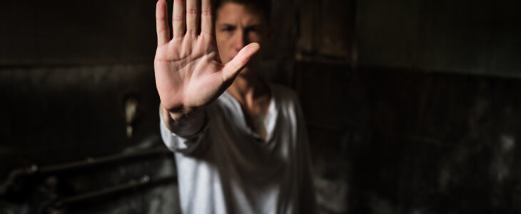 Close-up of a young man making a stop gesture.